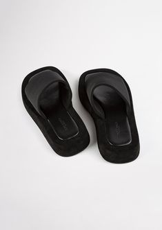 We're know you love effortless style. Cue our Isabel slides in classic black. Featuring an elevated platform foot bed, with simple fabric strap design, they're the perfect Summer sandal for the minimalist. - Material: Fabric upper and rubber lining - Toe-shape: Round toe shape - Pattern: Fabric strap - Fit: Runs true to size - Heel Height: 1.5cm Black Slip-on Platform Slippers With Thick Bottom, Black Leather Footbed Platform Slide Slippers, Black Leather Slide Platform Slippers, Modern Black Slip-on Flip Flops, Black Platform Toe Post Flip Flops, Black Toe Post Platform Flip Flops, Modern Black Platform Slippers With Rubber Sole, Modern Black Platform Slippers With Textured Sole, Black Leather Platform Slippers With Thick Bottom