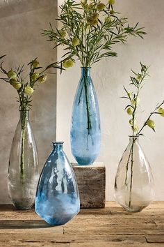 three vases with flowers in them sitting on a table