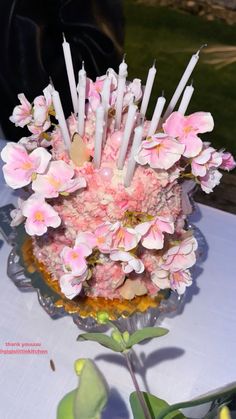 a cake with candles and flowers on it