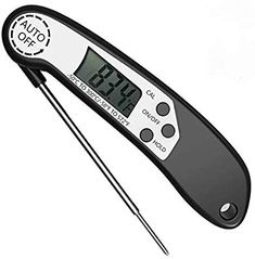 an electronic thermometer with two needles in front of it on a white background