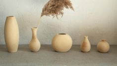 a group of vases sitting next to each other on top of a cement floor