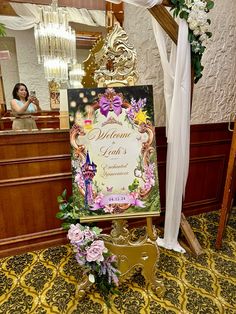 a sign that is sitting on the ground in front of a table with flowers and decorations