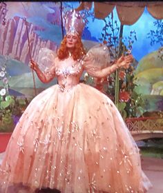 a woman in a pink dress and tiara on the set of disney's beauty and the beast