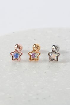 The 'AURORA STARBUST' earrings are a stunning pair of stud earrings that feature a starburst design with a sparkling cubic zirconia stone in the center. The stone is set in a hollowed-out star-shaped clasp and the design is reminiscent of a burst of light, just like the stunning aurora borealis. These earrings are small in size, making them perfect for everyday wear, but the sparkly design is sure to catch the eye of anyone who sees them. Please note that the clasp on these earrings is designed Celestial Star-shaped Sparkling Earrings, Sparkling Star-shaped Celestial Earrings, Celestial Star-shaped Piercings For Gifts, Celestial Star-shaped Piercings As Gift, Celestial Star Piercings Gift, Rose Gold Star Charm Earrings, Rose Gold Star Earrings With Star Charm, Star-shaped Cubic Zirconia Earrings With Star Charm, Rose Gold Star-shaped Earrings With Star Charm