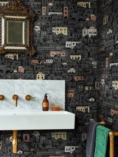 a bathroom sink sitting under a mirror next to a wall mounted faucet with two soap dispensers on it