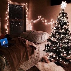 a bedroom decorated for christmas with lights and a laptop