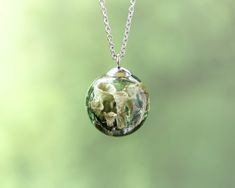 Step into the enchanted world of the forest with this botanical necklace, featuring real pixie cup lichen 🍃 preserved in a terrarium-style pendant. Perfect for those who embrace the beauty of nature, this terrarium necklace for men is a unique piece of goblincore jewelry that captures the essence of the woods. This forest necklace is an ideal gift for nature lovers, especially those who appreciate the magical and rugged elements of the natural world. Whether for a birthday or a special occasion, this necklace offers a piece of the forest to carry with you. 🌿 Our Botanical Jewelry: https://www.etsy.com/shop/NatureResinJewelry?section_id=51200953 💚 Handmade with love and care 💚 ADDITIONAL INFORMATION 🎁 This unique nature necklace comes carefully packaged in a gift box, making it a perfe Pixie Cup Lichen, Goblincore Jewelry, Forest Necklace, Terrarium Necklace, Necklace Mens, Nature Necklace, Botanical Jewelry, Necklace For Men, Gifts For Nature Lovers