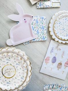 several plates and napkins on a table with bunny ears in the top one is pink