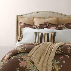 a bed with floral comforter and pillows on it