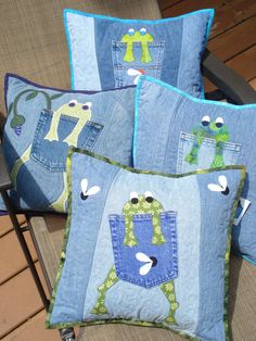 four pillows made to look like jeans on a patio chair, with frog appliqued in the pocket