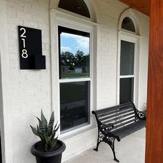 a black bench sitting in front of a white building