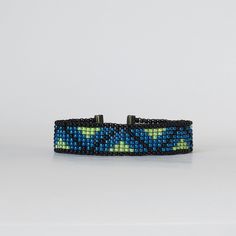 a blue and green beaded bracelet on a white background