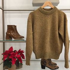 a pair of boots and a sweater hanging on a rack