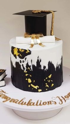 a graduation cake is decorated with black and gold paint