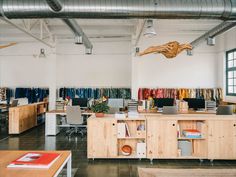 an open office space with desks, chairs and bookshelves on the walls