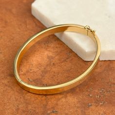 18KT yellow gold 6mm wide, polished-finish, oval, flat, hinged bangle bracelet. The perfect, everyday bangle bracelet in high quality 18k gold! Width: 6mm Length around inside: 6.75” Inside diameter: 2.375" Shown on a 6" wrist Width: 6mm Weight: 12.69 grams High end + designer piece Hallmarked / Stamped 18KT Hollow Oval in shape Hinged and figure 8 safety latch Luxury Oval Bangle With Polished Finish, Oval Gold Bracelet With Polished Finish For Anniversary, Classic Everyday Oval Gold Bracelet, Classic Oval Gold Bracelet With Polished Finish, Oval Bangle With Polished Finish For Anniversary, Modern Oval Yellow Gold Bangle, Modern Yellow Gold Oval Bangle, Everyday Oval Polished Bracelets, Mens Bangles