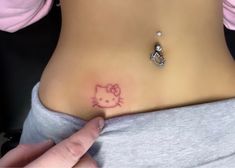 a hello kitty tattoo on the side of a woman's stomach is shown in this image