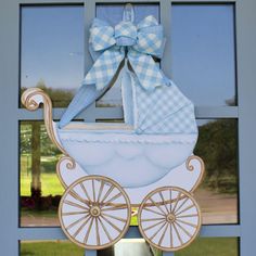 a paper cutout of a baby's carriage is hanging on the front door