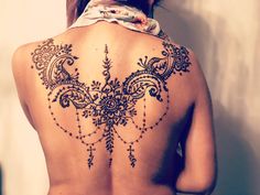 the back of a woman's body is decorated with intricate designs