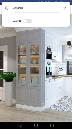 a kitchen with white cabinets and an oven in the corner, next to a potted plant