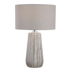 a table lamp with a white shade on it and a light grey fabric shade on the base