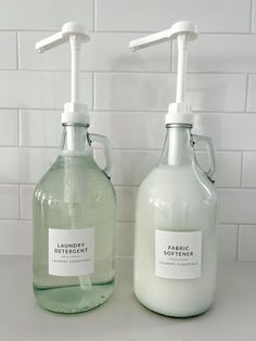 two soap dispensers sitting next to each other on a counter