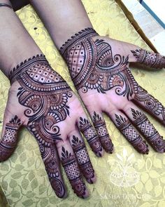 two hands with henna designs on them