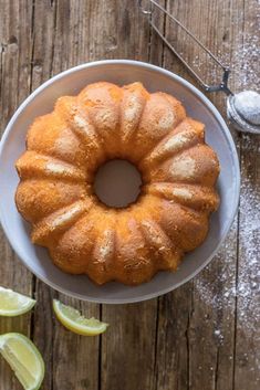 a bundt cake sitting on top of a white plate next to sliced limes