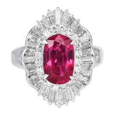 This chic ruby and diamond cocktail ring is crafted in solid platinum, weighing 11.8 grams and 15 mm x 20 mm x 9 mm in height. Showcasing a prominent GIA lab reported oval-shaped, prong-set purplish pinkish red ruby, weighing approximately, 2.29 carats and measuring 10.14 x 6.28 x 3.74 mm. Further accented by (36) baguette diamonds & (20) round-cut diamond, prong-set & channel set at the sides, collectively weighing approximately 1.60 carats, graded G-H color and VS clarity.  Currently a US size Oval Ruby Ring In Platinum For Formal Occasions, Formal Oval Ruby Ring In Platinum, Diamond Cocktail Ring, Pinkish Red, Jewelry Appraisal, Diamond Cocktail Rings, Ruby Diamond, Channel Set, Red Ruby