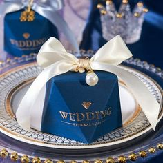 a blue box with a white bow on it sitting on top of a silver and gold plate