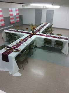 a long table set up with purple and white linens for a formal dinner or banquet