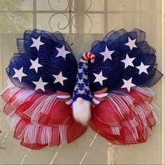 a red, white and blue wreath with an american flag design on it's wings