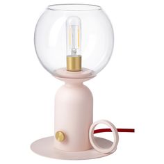 a light that is inside of a glass ball on top of a pink stand with a red cord