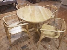 a wooden table and four chairs in a room with hard wood flooring on the ground