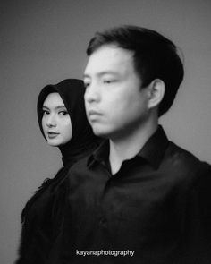 black and white photograph of man and woman in hijab looking at each other