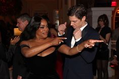 a man and woman dancing together at a party