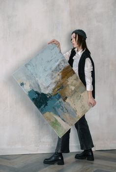 a woman holding a large piece of art in her hands