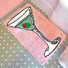 a pink bathroom rug with an image of a vase on it