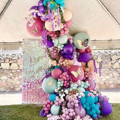 a large number of balloons in the shape of a tree with flowers and butterflies on it