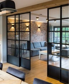 a living room filled with furniture next to a window covered in frosted glass doors