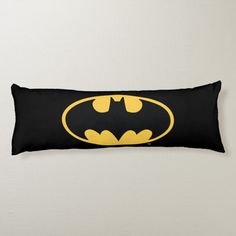 a black and yellow rectangular pillow with the batman symbol on it's front side