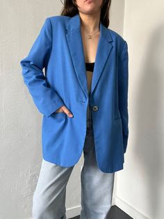 Classic blue single breasted blazer with a pointed notched collar, pockets, a blue lining, shoulder pads and a single mother-of-pearl center button closure. In excellent vintage condition. DETAILSLabel: DressbarnMaterial: 50% Polyester, 50% Rayon SIZE & MEASUREMENTSTag Size: 14Length: 32"Bust: 43"Waist: 44"Sleeve: 24"Shoulder: 18" Classic Blue Blazer With Pockets, Blue Business Casual Blazer With Button Closure, Casual Blue Blazer With Suit Collar, Business Casual Blue Blazer With Button Closure, Blue Blazer With Button Closure For Semi-formal Occasions, Chic Blue Business Blazer, Blue Single Button Outerwear For Office, Blue Single Button Blazer For Fall, Blue Blazer With Suit Collar For Spring