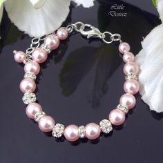 "MATCHING EARRINGS are available here: https://www.etsy.com/listing/264695420/pink-pearl-earrings-bridal-earrings MATCHING NECKLACE is available here: https://www.etsy.com/listing/465634043/pearl-necklace-pink-pearl- A beautiful bracelet made with lustrous 8mm and 6mm Pink Pearls along with rhinestone spacers and rhinestone encrusted balls for added sparkle. Being a versatile piece, this bracelet will go with almost any pearl jewelry. Finished with a large sterling silver clasp for easy one hand Adjustable Pink Crystal Bracelet With Rhinestones, Pink Adjustable Crystal Bracelet With Rhinestones, Pink Crystal Wedding Bracelets, Pink Rhinestone Beaded Bracelet As Gift, Pink Rhinestone Round Bead Jewelry, Pink Crystal Bracelets For Party, Pink Pearl Bracelet For Wedding, Adjustable Pink Crystal Bracelet For Wedding, Pink Rhinestone Wedding Jewelry