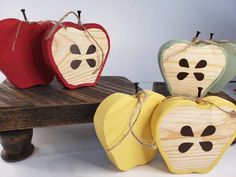 three wooden apples are sitting on a bench