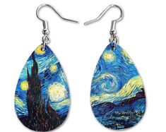 a pair of earrings with an image of the starry night