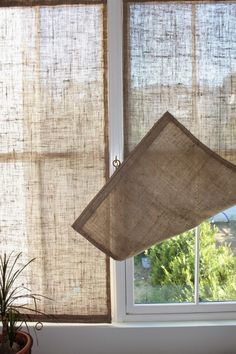 the window is covered in burlap and has a lamp hanging from it's side