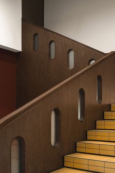 the stairs are made of wood and have round windows on each side, along with yellow brick steps