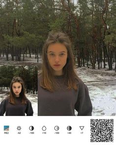 the girl is looking at the camera while standing in front of trees