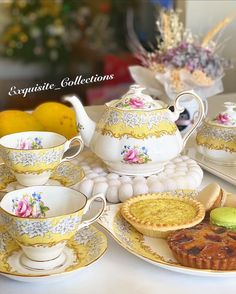 a table topped with plates and cups filled with desserts next to lemons on top of each other