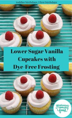 some cupcakes with white frosting and raspberries on top are sitting on a cooling rack